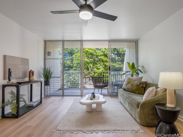 living room featuring expansive windows, light wood-type flooring, and ceiling fan