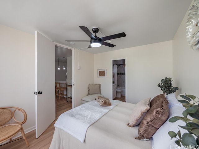 bedroom featuring light wood-type flooring, a walk in closet, a closet, ceiling fan, and connected bathroom