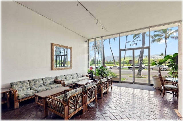 tiled living room featuring a mountain view, a wall of windows, and plenty of natural light