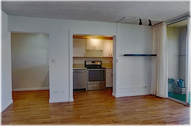 kitchen with light hardwood / wood-style floors, a textured ceiling, and appliances with stainless steel finishes