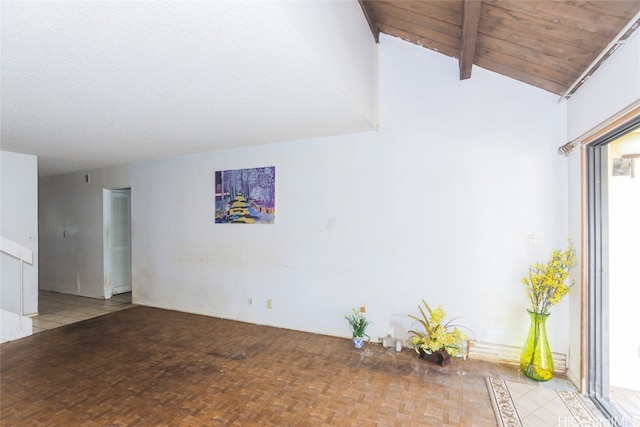 spare room with light parquet flooring and lofted ceiling with beams