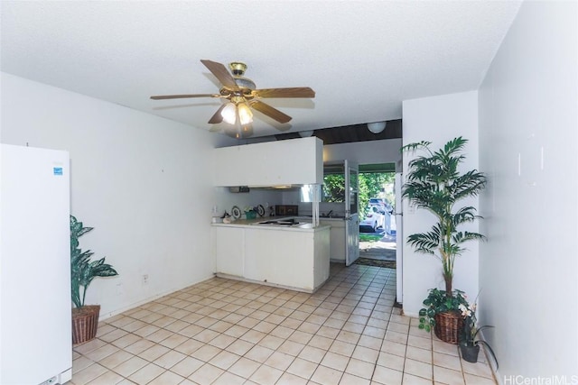 kitchen with white cabinets, white fridge, ceiling fan, and light tile patterned flooring