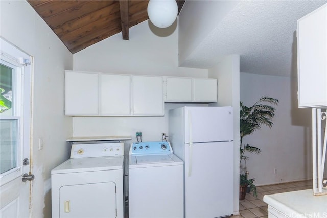 laundry room featuring a textured ceiling, separate washer and dryer, and light tile patterned flooring