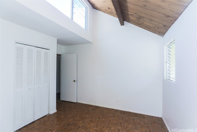 unfurnished bedroom featuring vaulted ceiling with beams, dark parquet flooring, wooden ceiling, and a closet