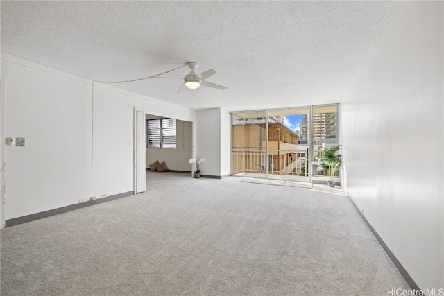 carpeted spare room featuring a ceiling fan, baseboards, and a textured ceiling