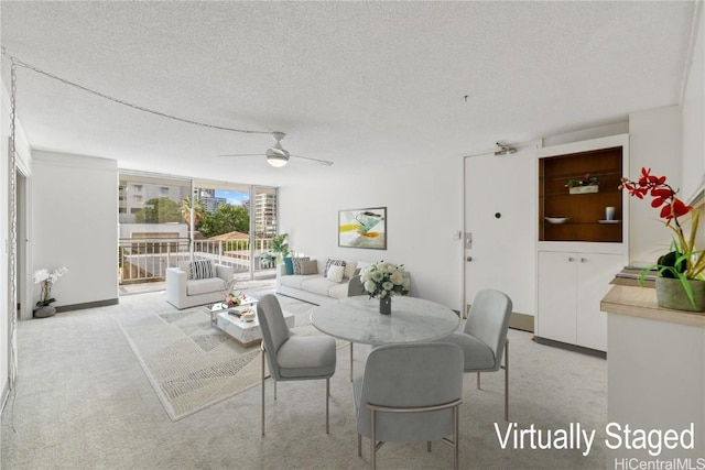 carpeted dining area featuring a textured ceiling and a ceiling fan