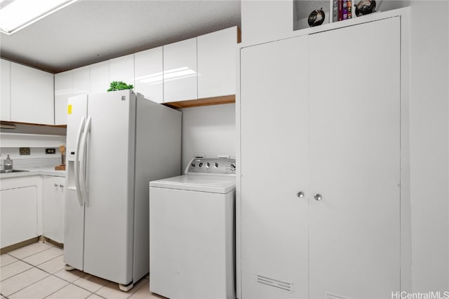 laundry area featuring a sink, washer / dryer, light tile patterned floors, and laundry area