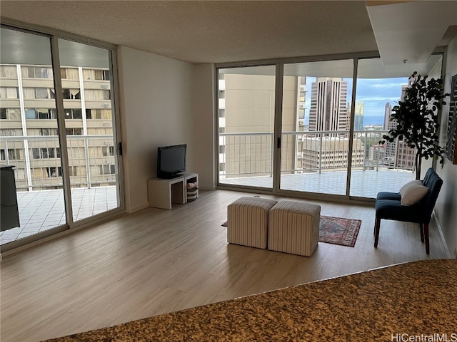 unfurnished living room with a wall of windows, hardwood / wood-style floors, and plenty of natural light