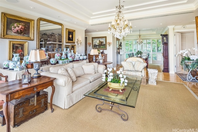 living room with ornamental molding, an inviting chandelier, hardwood / wood-style floors, and a tray ceiling