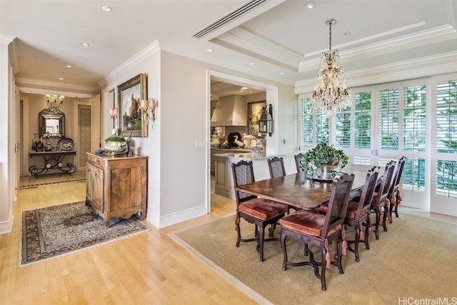 dining space with light hardwood / wood-style floors, crown molding, and a wealth of natural light