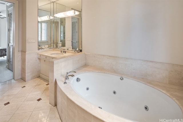 bathroom featuring vanity, a relaxing tiled tub, and tile patterned flooring