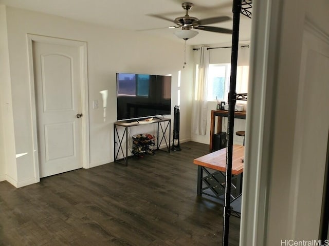 living room featuring ceiling fan and dark wood-type flooring