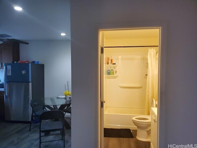 full bathroom featuring vanity, hardwood / wood-style flooring, toilet, and shower / bathtub combination with curtain