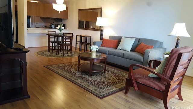 living room with a notable chandelier and light hardwood / wood-style flooring