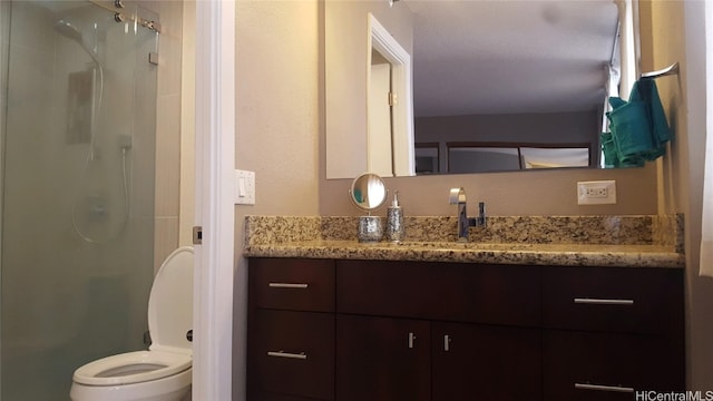 bathroom featuring vanity, toilet, and walk in shower