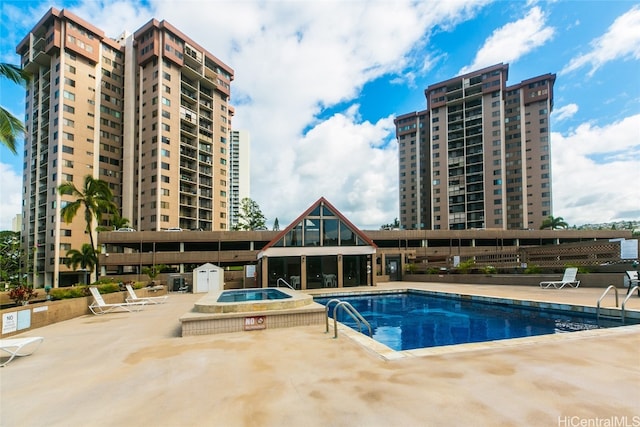 view of pool featuring a hot tub and a patio area