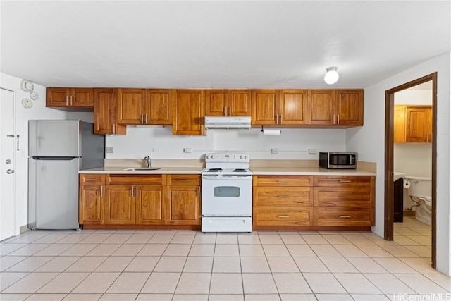 kitchen with appliances with stainless steel finishes, sink, and light tile patterned floors