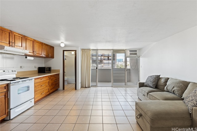 kitchen featuring electric stove, a wall mounted AC, and light tile patterned floors