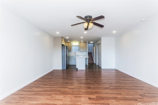 unfurnished living room featuring sink, hardwood / wood-style floors, crown molding, and ceiling fan