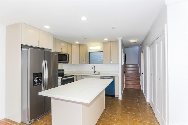 kitchen featuring light stone counters, a kitchen island, appliances with stainless steel finishes, sink, and tile patterned flooring