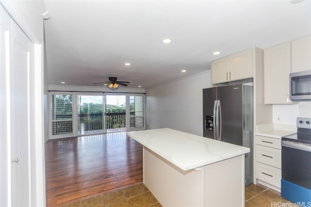 kitchen with appliances with stainless steel finishes, a kitchen island, ceiling fan, white cabinets, and dark wood-type flooring