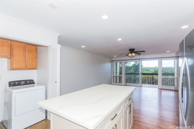 kitchen with hardwood / wood-style floors, ceiling fan, white cabinetry, stainless steel refrigerator, and a center island