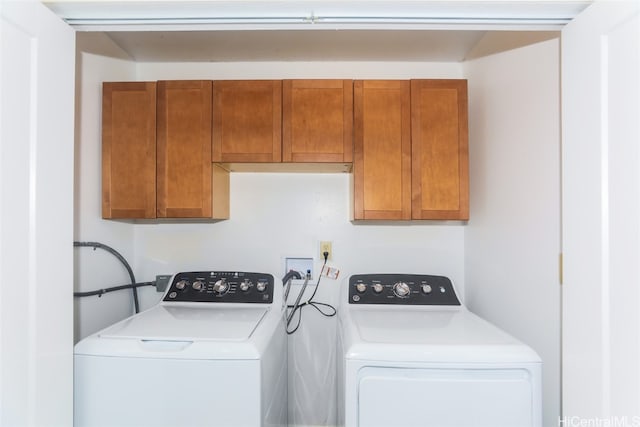 laundry room with separate washer and dryer and cabinets