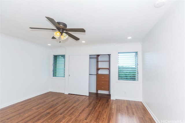 unfurnished bedroom featuring a closet, ornamental molding, dark wood-type flooring, and ceiling fan