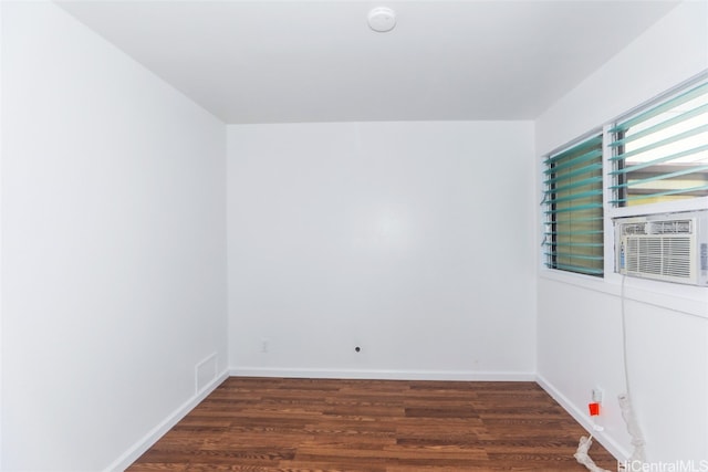 spare room with cooling unit and dark hardwood / wood-style flooring