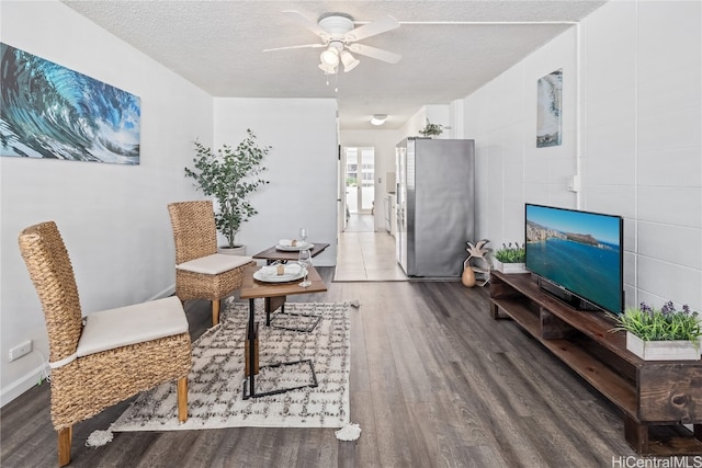 dining area featuring a textured ceiling, wood-type flooring, tile walls, and ceiling fan