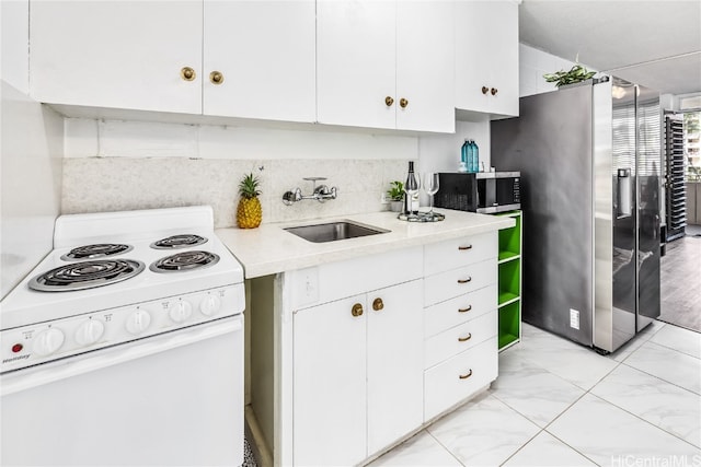 kitchen with stainless steel fridge, white cabinets, white electric range oven, and sink