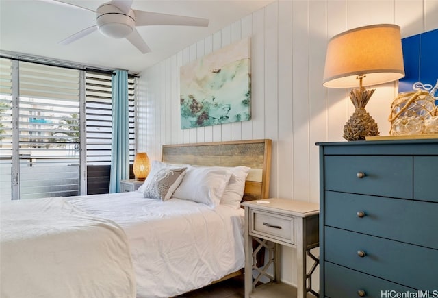 bedroom with wood walls and ceiling fan