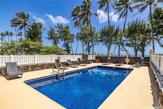 view of pool featuring a water view and a patio