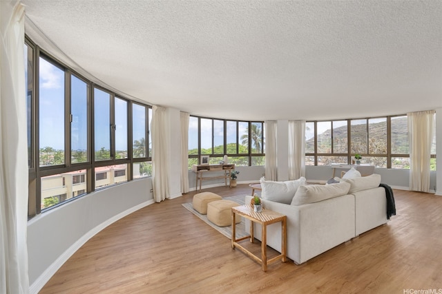 6770 Hawaii Kai Dr Unit 302, Honolulu, HI 96825 - living area featuring a textured ceiling, light wood-style flooring, and baseboards