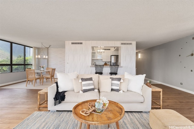 living room featuring hardwood / wood-style flooring, a textured ceiling, and a chandelier