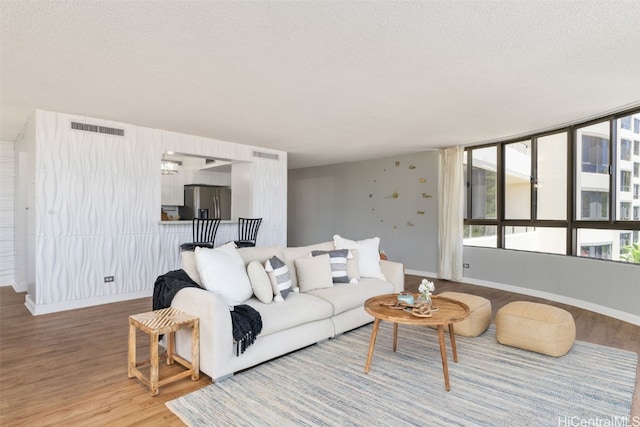 living room with a textured ceiling and hardwood / wood-style flooring