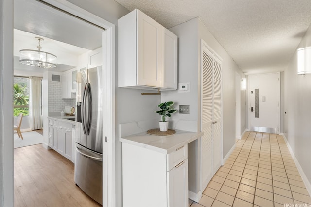 6770 Hawaii Kai Dr Unit 302, Honolulu, HI 96825 - kitchen featuring stainless steel refrigerator with ice dispenser, white cabinets, tasteful backsplash, a chandelier, and a textured ceiling