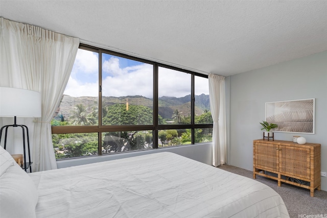 6770 Hawaii Kai Dr Unit 302, Honolulu, HI 96825 - carpeted bedroom featuring a mountain view, multiple windows, a wall of windows, and a textured ceiling