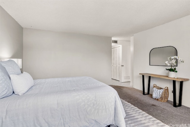 bedroom featuring a textured ceiling and light colored carpet