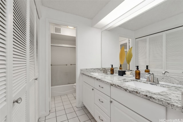 full bathroom featuring a textured ceiling, shower / bath combination with glass door, toilet, tile patterned floors, and vanity