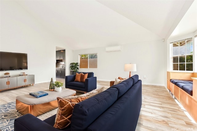 living room featuring lofted ceiling, a healthy amount of sunlight, and light wood-type flooring