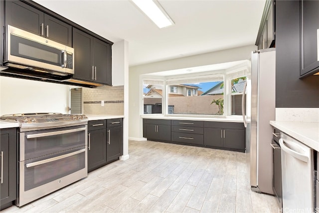 kitchen featuring decorative backsplash, stainless steel appliances, and light hardwood / wood-style floors