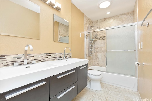 full bathroom with vanity, toilet, shower / bath combination with glass door, and backsplash