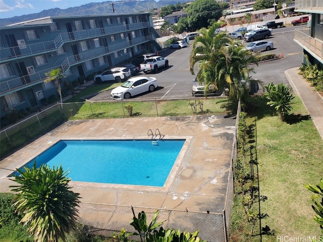 view of swimming pool featuring a yard and a mountain view