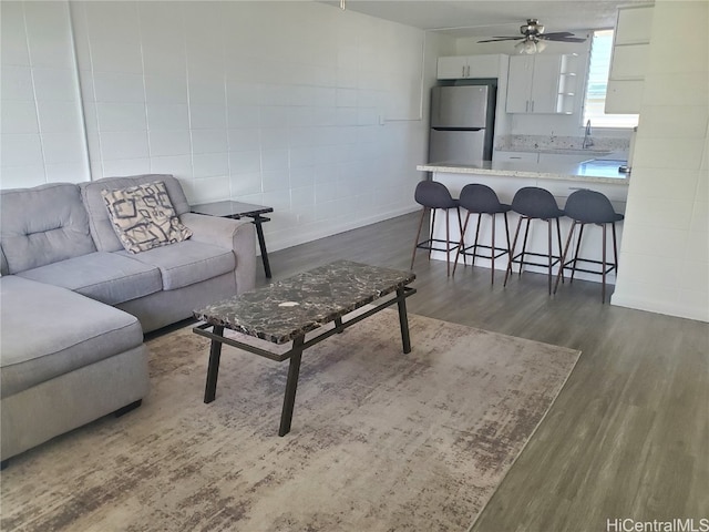 living room featuring ceiling fan, sink, and dark hardwood / wood-style flooring