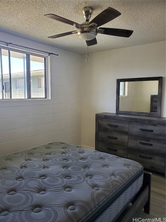 bedroom featuring a textured ceiling, wood-type flooring, and ceiling fan