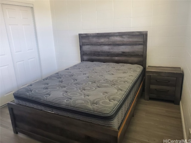 bedroom featuring tile walls, a closet, and dark hardwood / wood-style flooring