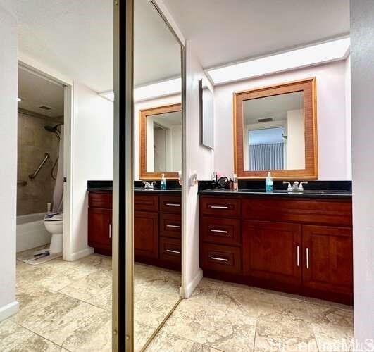 bathroom featuring vanity, toilet, and tiled shower