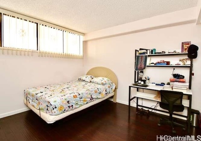 bedroom featuring dark wood-type flooring and a textured ceiling