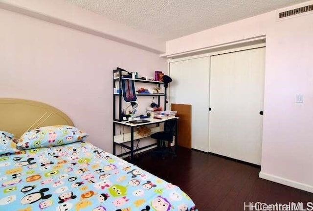 bedroom with a textured ceiling and dark hardwood / wood-style floors